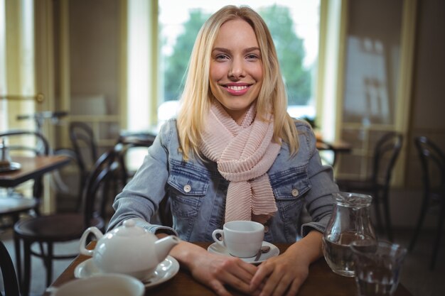 Smiling woman sitting with a cup of coffee in cafÃ©