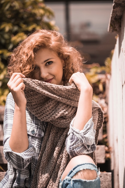 Free photo smiling woman on steps holding scarf