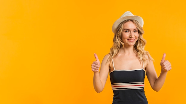 Free photo smiling woman in summer clothes showing thumbs up