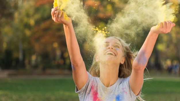 Free photo smiling woman throwing color in the air