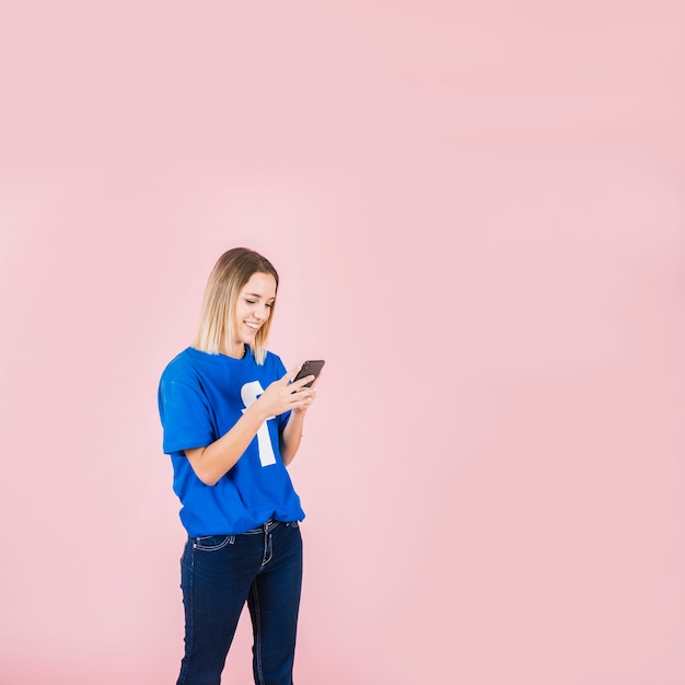 Smiling woman wearing facebook t-shirt using mobile phone