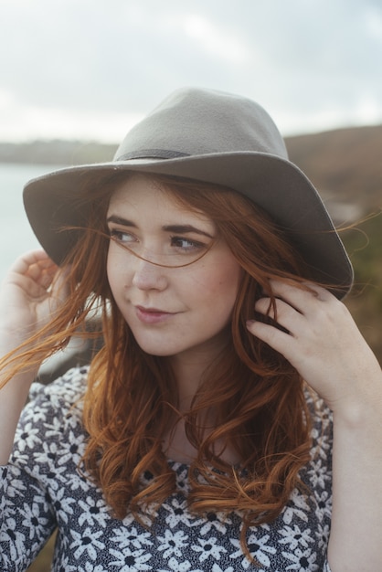 smiling woman wearing a hat in nature