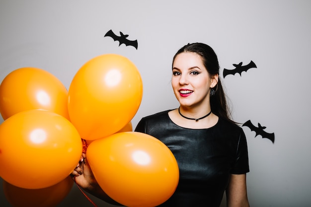 Smiling woman with balloons at bats