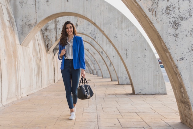 Free Photo smiling woman with blue jacket walking