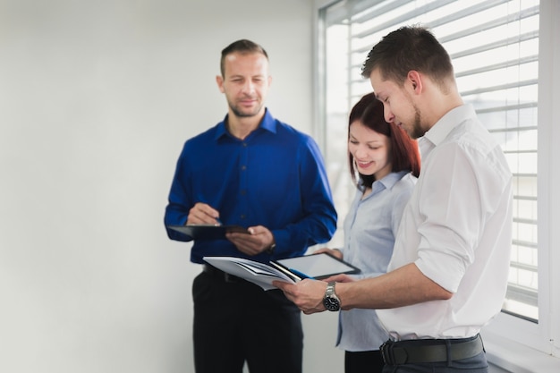 Free photo smiling woman with coworkers in office