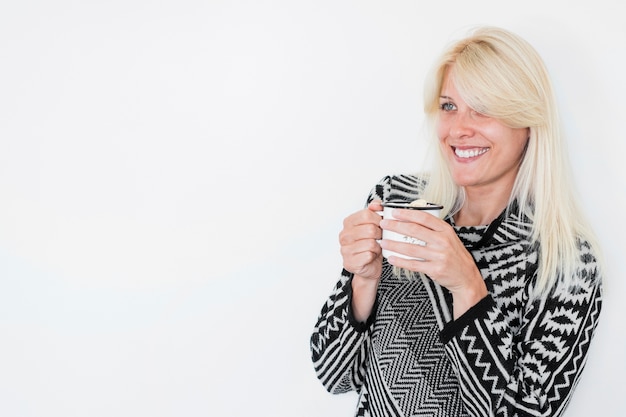 Free Photo smiling woman with hot beverage looking away