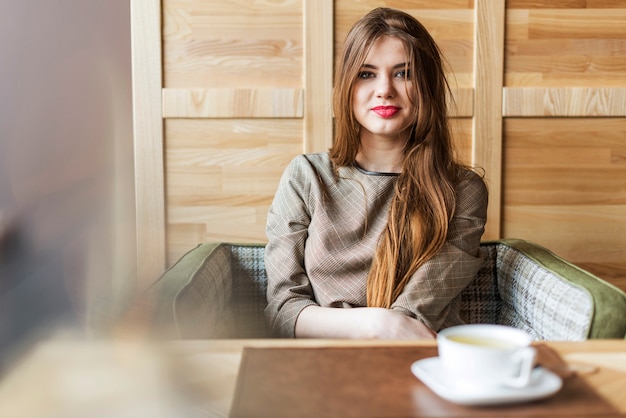 Smiling woman with long hair in a coffee shop