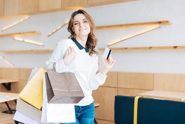 Smiling woman with paper bags and credit card