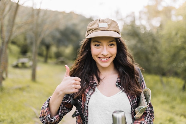 Free photo smiling woman with thermos gesturing thumb-up