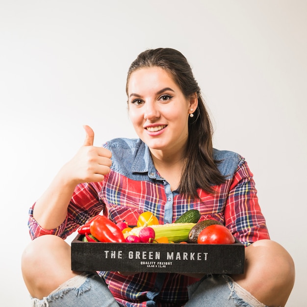 Smiling woman with vegetables gesturing thumb up