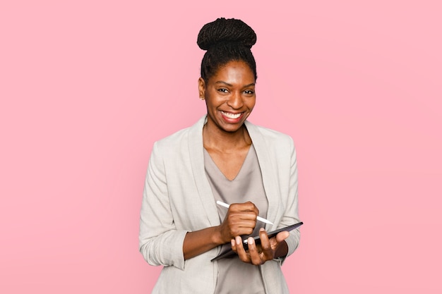 Smiling woman writing notes on tablet digital device