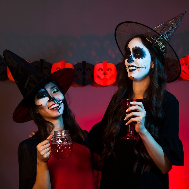 Smiling women dressed as witches