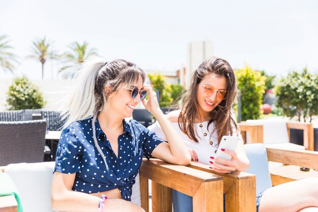 Smiling women looking at mobile phone