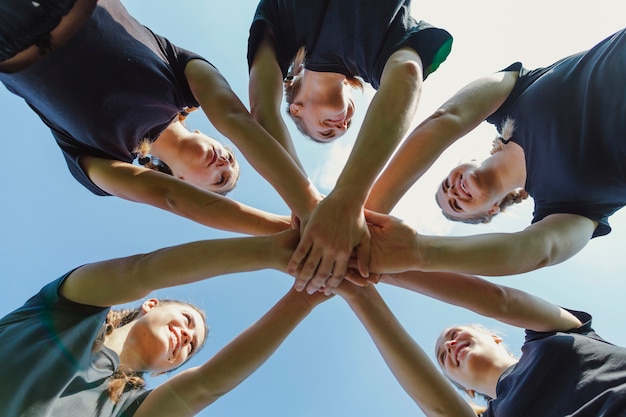 Free photo smiling women putting hands together