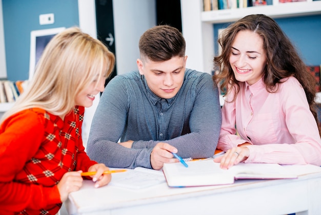 Smiling women studying with man