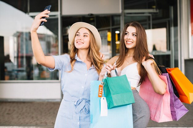 Smiling women taking selfies