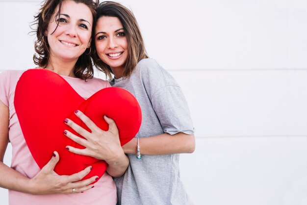 Smiling women with plush heart looking at camera