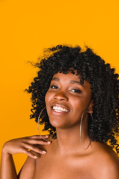 Smiling young African American female on colored background