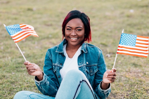 Smiling young black woman with American flags