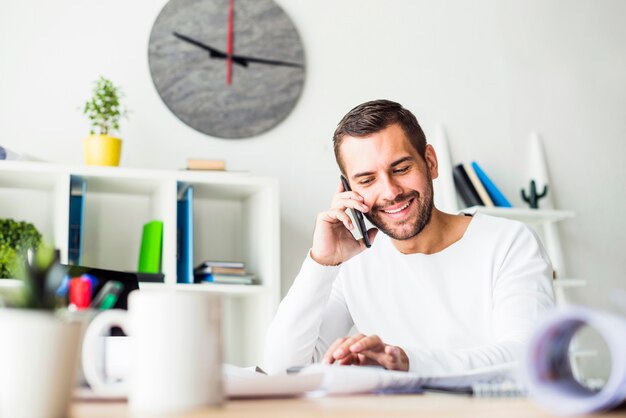 Smiling young businessman talking on smartphone