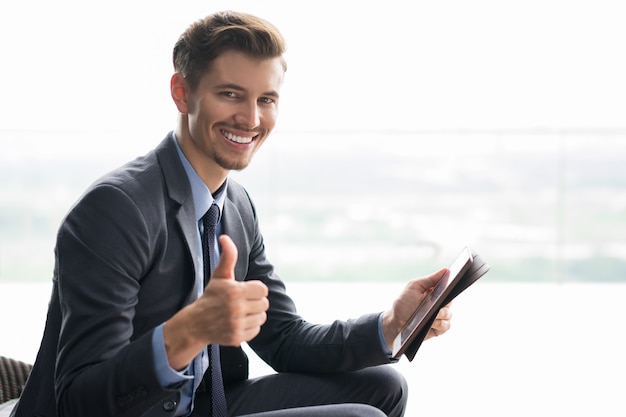 Smiling Young Businessman with Thumb Up and Tablet