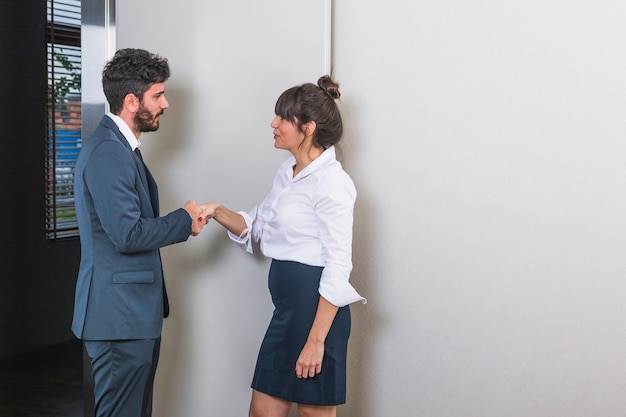 Smiling young businesspeople shaking hands