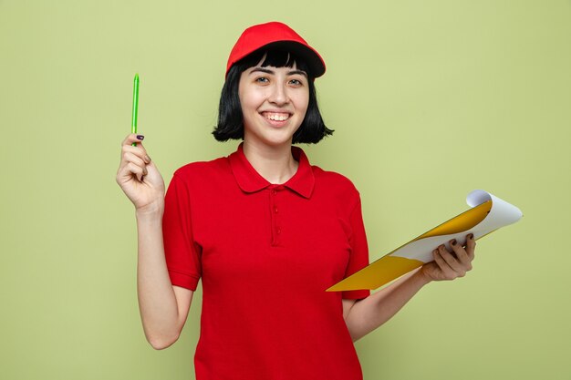 Smiling young caucasian delivery girl holding clipboard and pen 