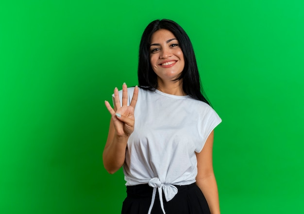 Smiling young caucasian girl gestures four with fingers 