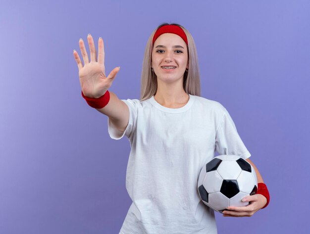 Smiling young caucasian sporty girl with braces wearing headband