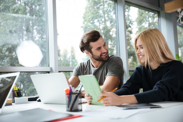 Smiling young colleagues sitting in office coworking