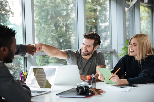 Free Photo smiling young colleagues sitting in office coworking