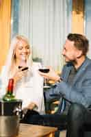 Free photo smiling young couple enjoying drinks together