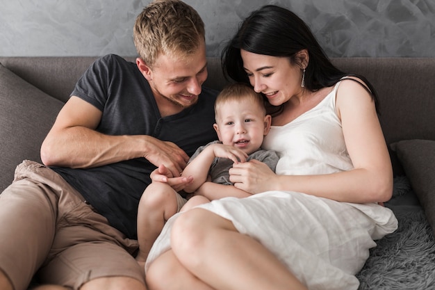 Smiling young couple sitting with their lovely little boy