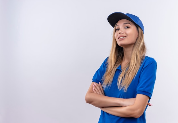 Free Photo smiling young delivery girl wearing blue uniform and cap crossing hands isolated on white