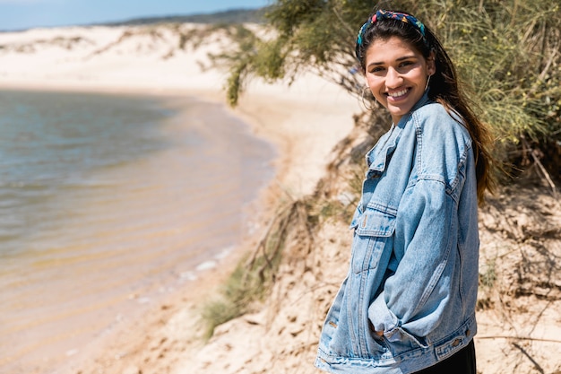 Free Photo smiling young female standing on seashore