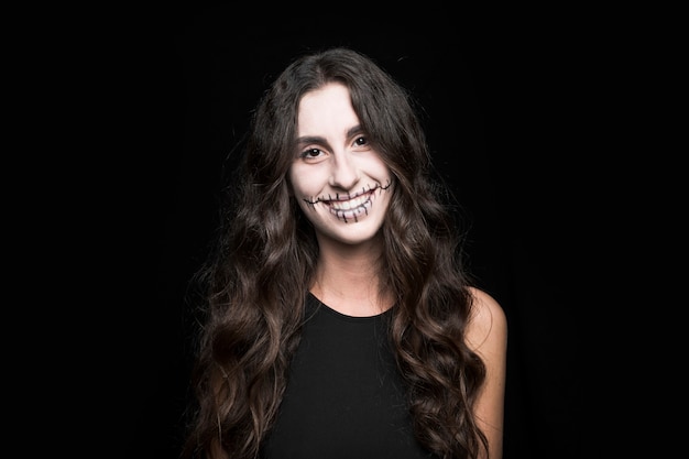 Smiling young female with creepy makeup