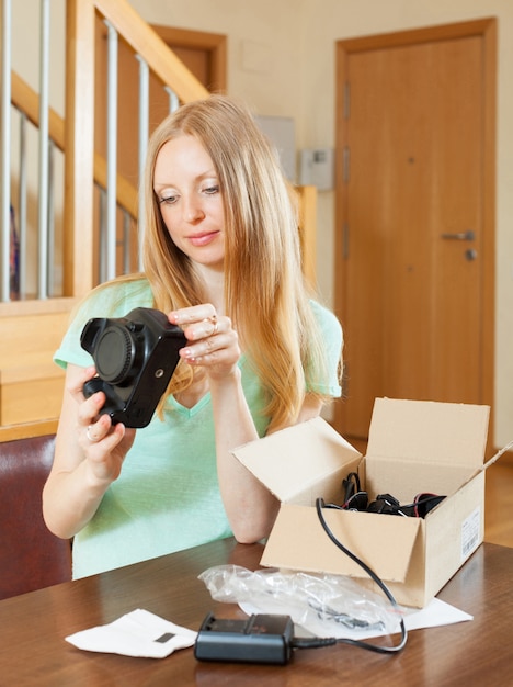 Smiling young  girl unpacking new digital camera