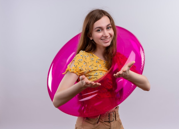 Free Photo smiling young girl wearing swim ring and showing empty hands on isolated white wall with copy space