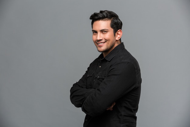 Smiling young handsome man standing isolated