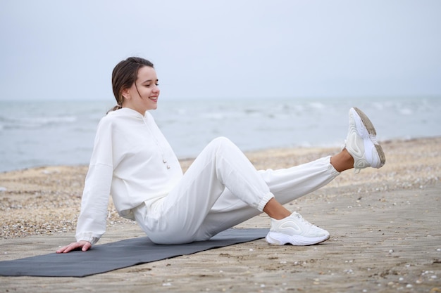 Free Photo smiling young lady doing her meditation at the beach high quality photo