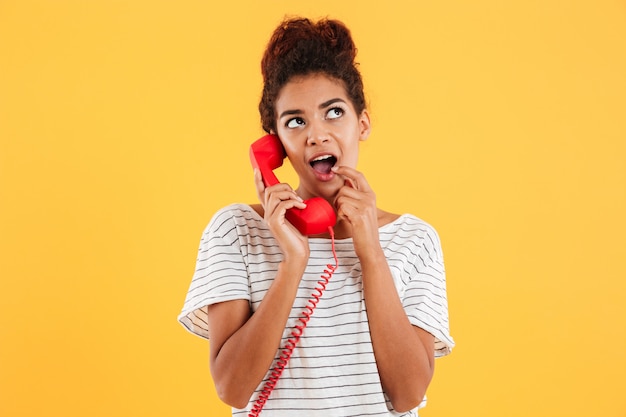 Free photo smiling young lady holding red handset isolated