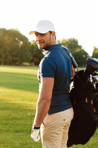 Free photo smiling young man in cap holding golf bag