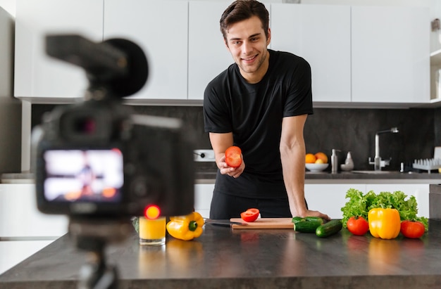 Free photo smiling young man filming his video blog episode