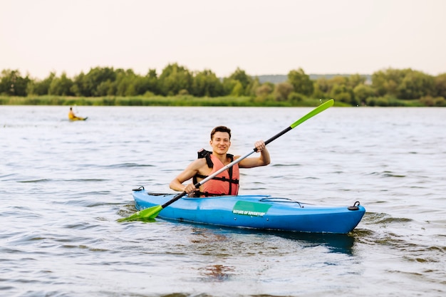 Free Photo smiling young man kayaking on lake