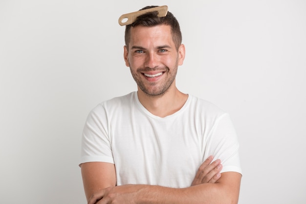 Smiling young man with comb in his hair looking at camera