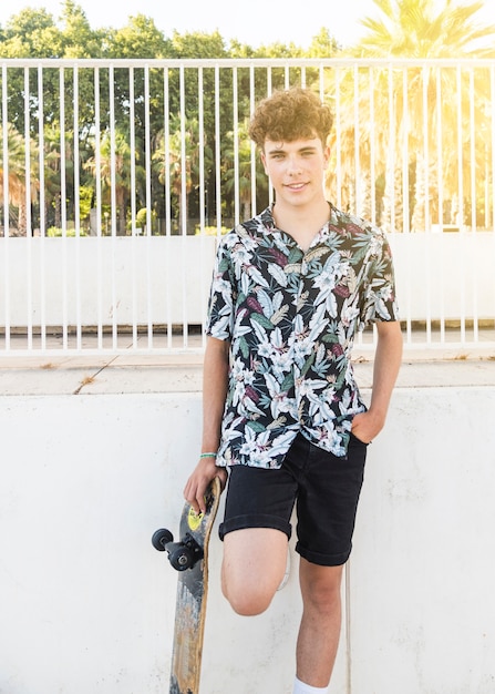 Free photo smiling young man with skateboard