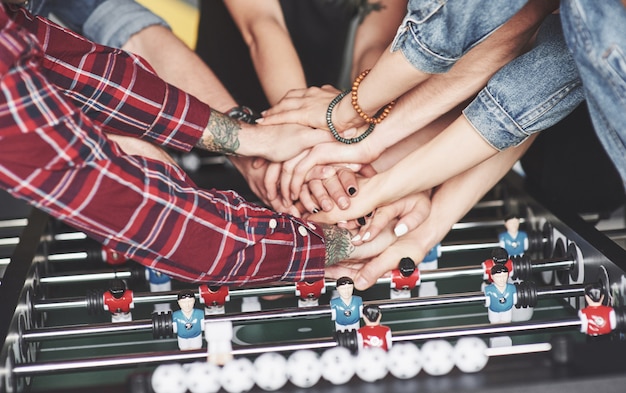 Free photo smiling young people playing table football while on vacation