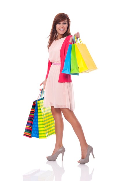 Smiling young woman carrying many shopping bags