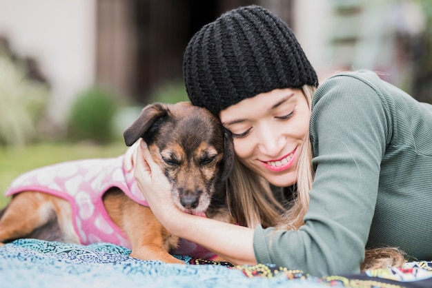 Smiling young woman cuddling her friendly dog