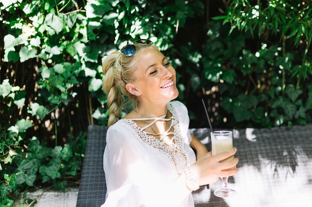 Smiling young woman enjoying the drink at outdoors